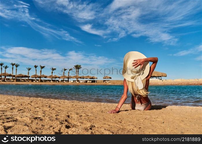 Young fashion woman sitting on the beach shore.. Young fashion woman sitting on the beach shore