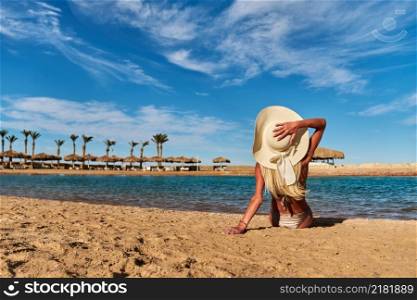 Young fashion woman sitting on the beach shore.. Young fashion woman sitting on the beach shore