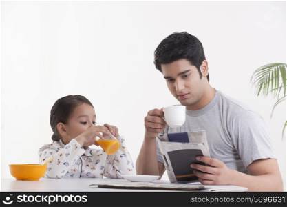 Young father and daughter having breakfast together