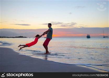 Young father and his little daughter on the seashore have fun together. Happy family concept. Little girl and happy dad having fun during beach vacation