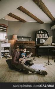 Young father and little daughter playing acoustic guitar in the room at home