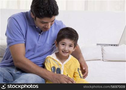 Young father assisting his son in drawing at home