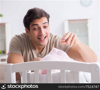 Young father enjoying time with newborn baby at home. The young father enjoying time with newborn baby at home