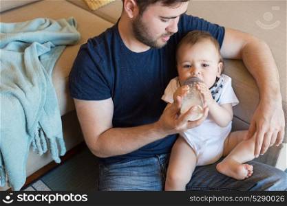 Young father feeding his baby with nursing bottle