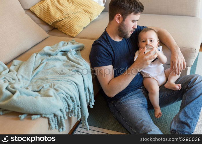 Young father feeding his baby with nursing bottle