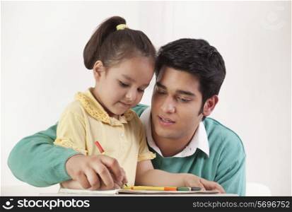 Young father helping her daughter in drawing