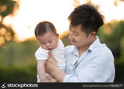 Young father holding a baby in his arms