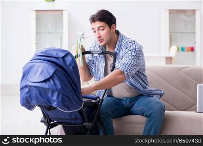 Young father looking after newborn baby at home