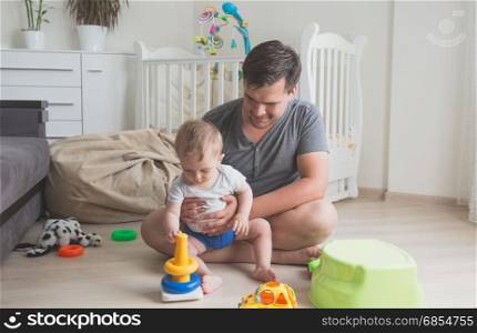 Young father playing with his 9 months old baby boy