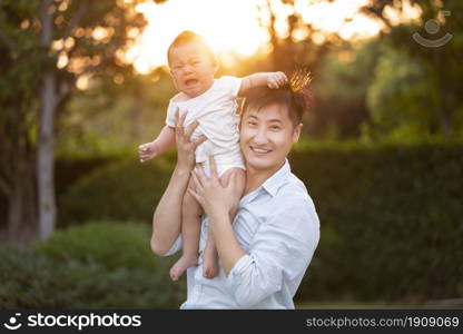 Young father raising his baby to play