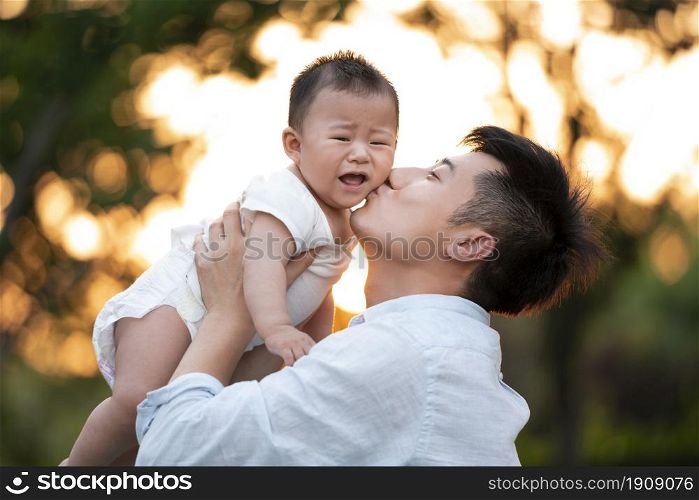 Young father raising his baby to play