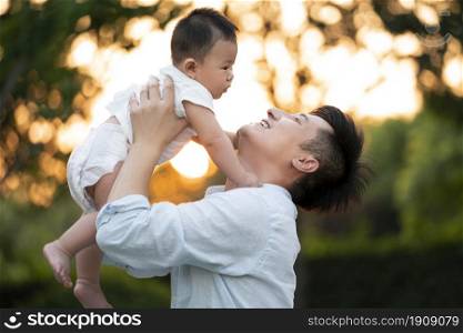 Young father raising his baby to play