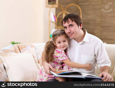 young father with a daughter at home in the living-room