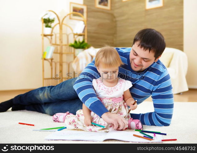 young father with a daughter at home in the living-room