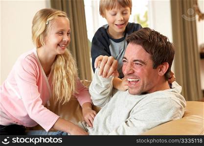 Young father with children having fun on sofa