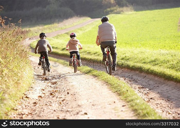 Young father with children ride bikes in park