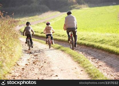 Young father with children ride bikes in park