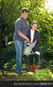 Young father working at garden with cute little daughter
