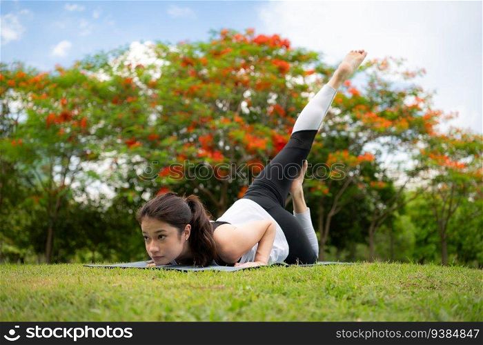 Young fema≤with outdoor activities in the city park, Yoga is her chosen activity.