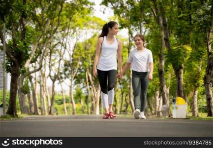 Young female and little girl with walking exercises in the city park