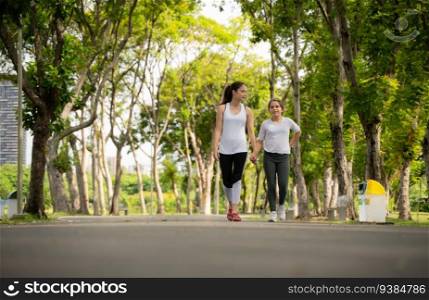 Young female and little girl with walking exercises in the city park