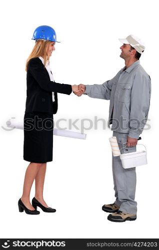 young female architect shaking hands with painter