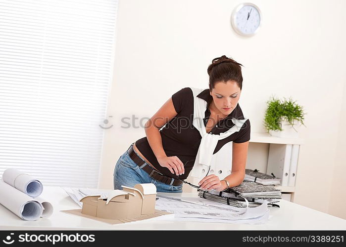 Young female architect with plans at the office