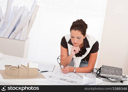 Young female architect with plans at the office