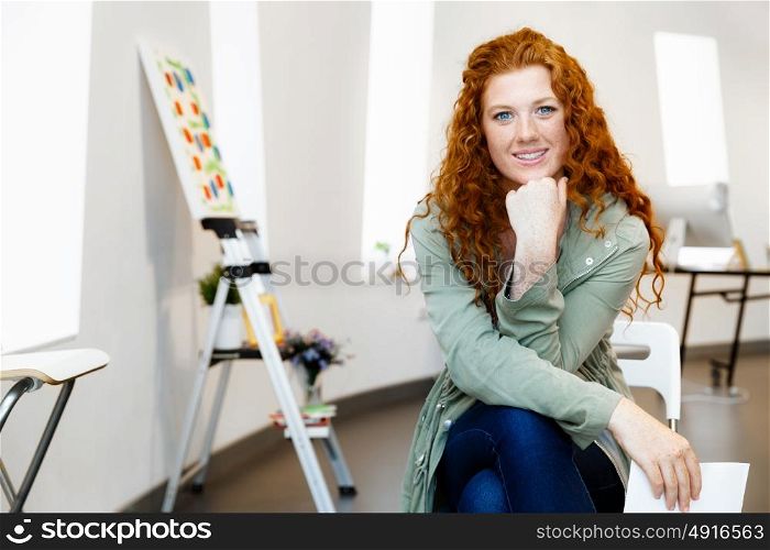 Young female artist with her picture. Young female artist in gallery with her picture