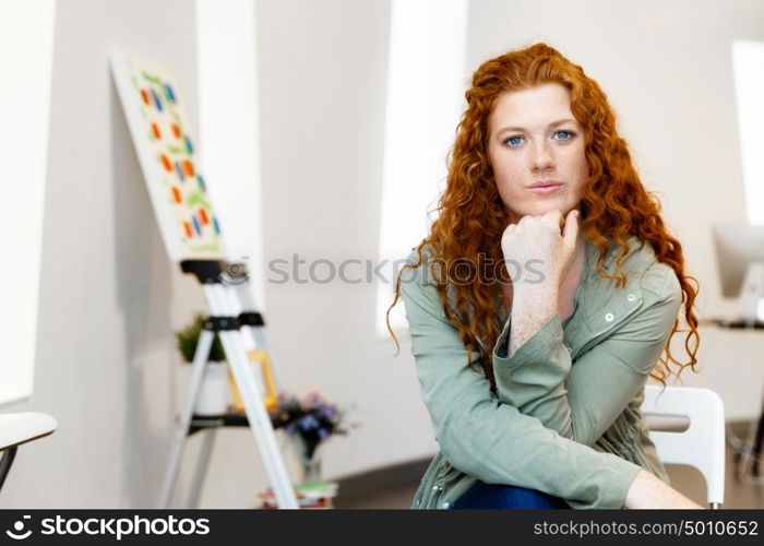 Young female artist with her picture. Young female artist in gallery with her picture