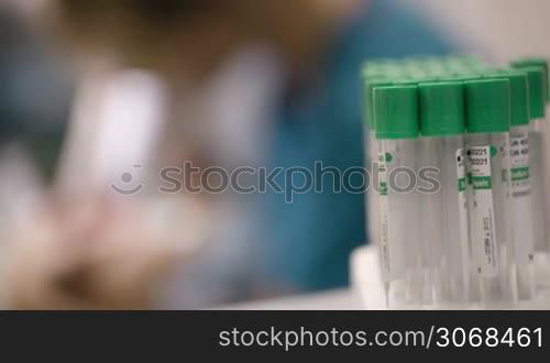 Young female beautician or nurse in a skin clinic doing laser skin treatment on a woman to rejuvenate her skin or treat scar tissue. Focus pulling from medical bottles to the doctor