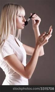 Young female beauty applying face powder