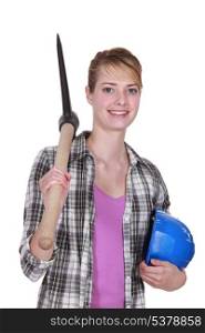 young female bricklayer posing with pickaxe and hard hat