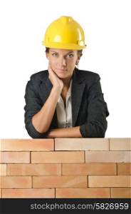 Young female builder near brick wall