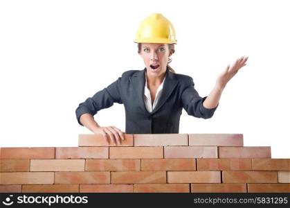 Young female builder near brick wall