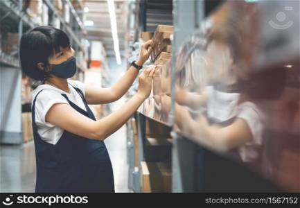 Young female buyer wearing protective face mask shopping during pandemic covid-19 at mall while her pregnancy. Asian Pregnant Woman looking and choosing or selecting products on shelf at supermarket.