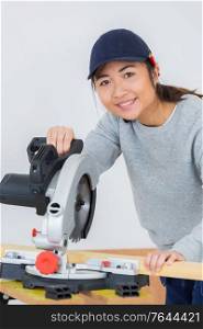 young female carpenter using a circular saw