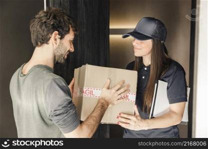 young female courier delivering parcel man home