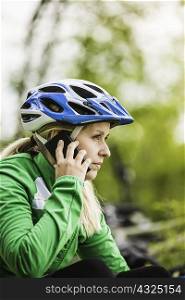Young female cyclist chatting on smartphone, Augsburg, Bavaria, Germany