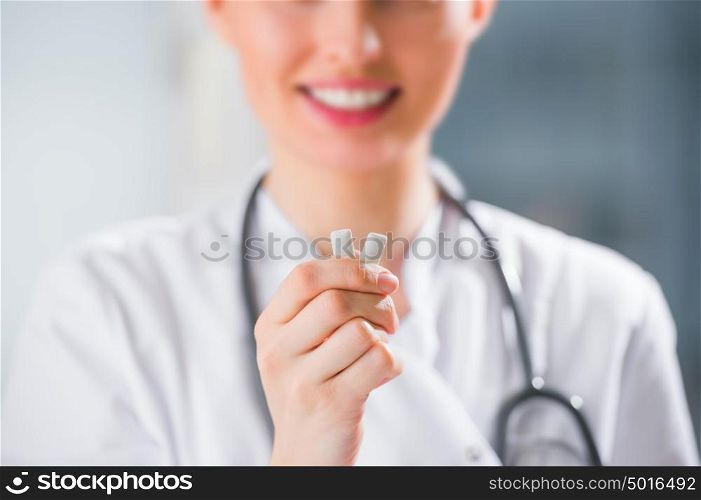 Young female dentist doctor holding chewing gum and smiling. Oral hygiene concept