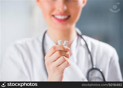 Young female dentist doctor holding chewing gum and smiling. Oral hygiene concept