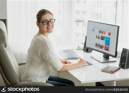 Young female designer working at home office at computer