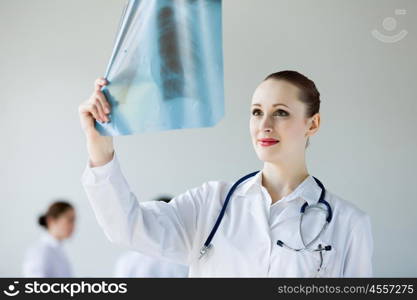 Young female doctor. Attractive young female doctor examining x-ray results