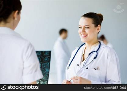Young female doctor. Attractive young female doctor examining x-ray results