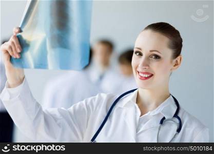 Young female doctor. Attractive young female doctor examining x-ray results