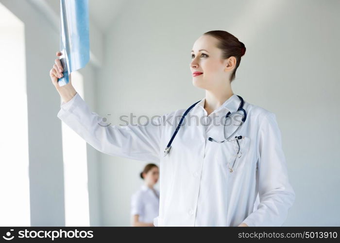 Young female doctor. Attractive young female doctor examining x-ray results