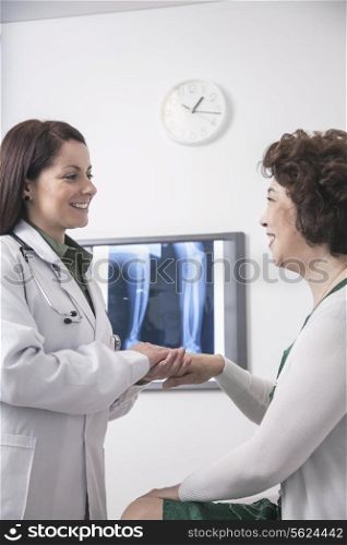 Young female doctor holding the hands of a patient