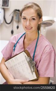 Young Female Doctor In Scrubs,Holding A Clipboard