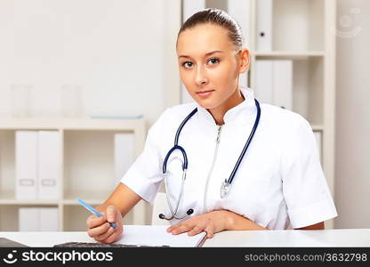 Young female doctor in white uniform at workplace