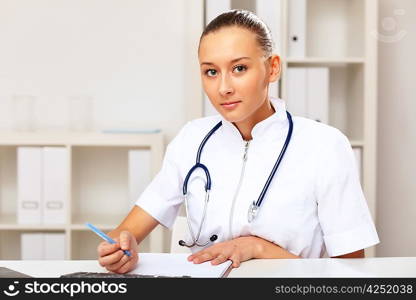 Young female doctor in white uniform at workplace